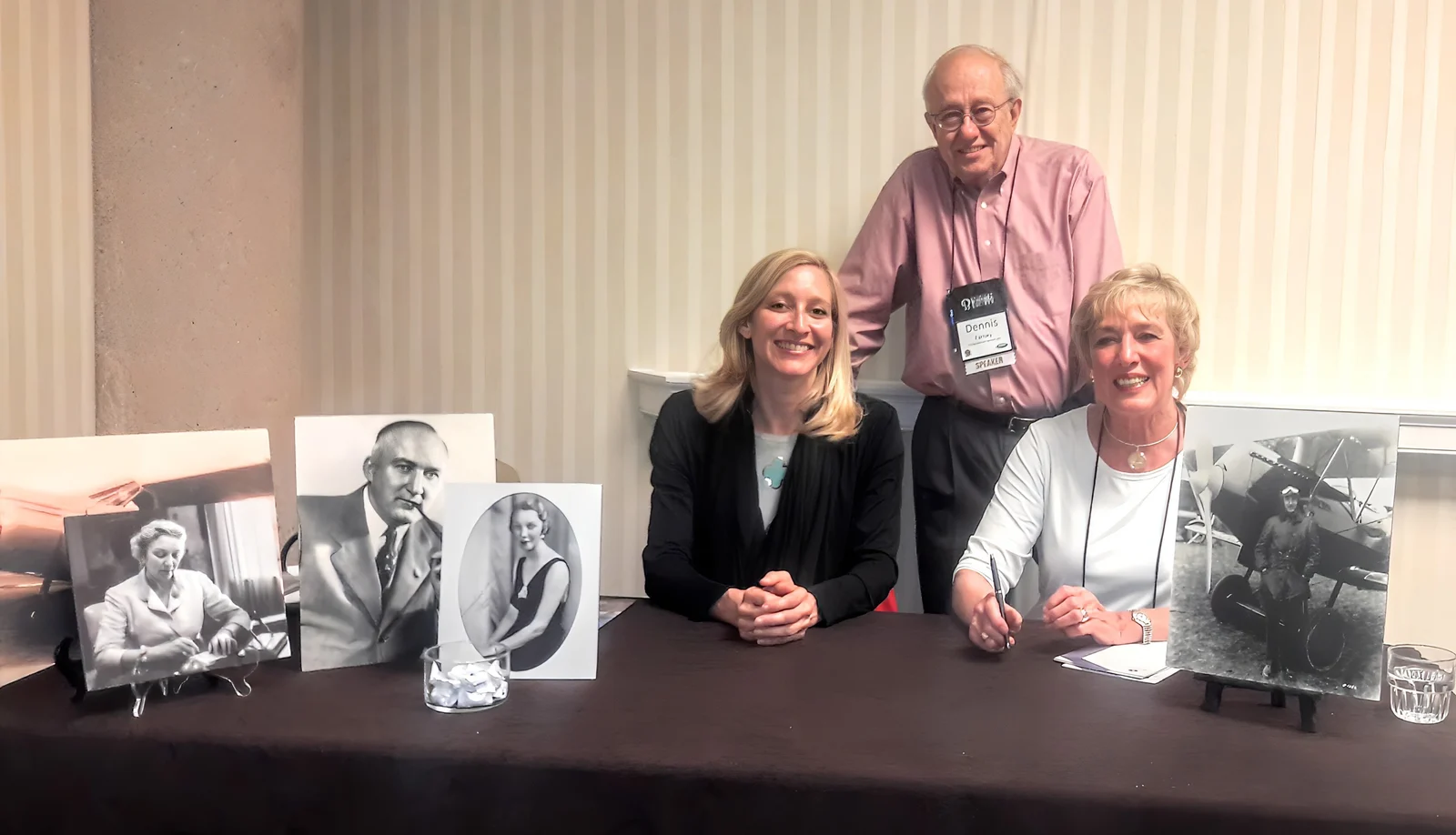 Jennifer Pitt, Dennis Farney and Mary Lynn Oliver at a book-signing table set with framed photographs