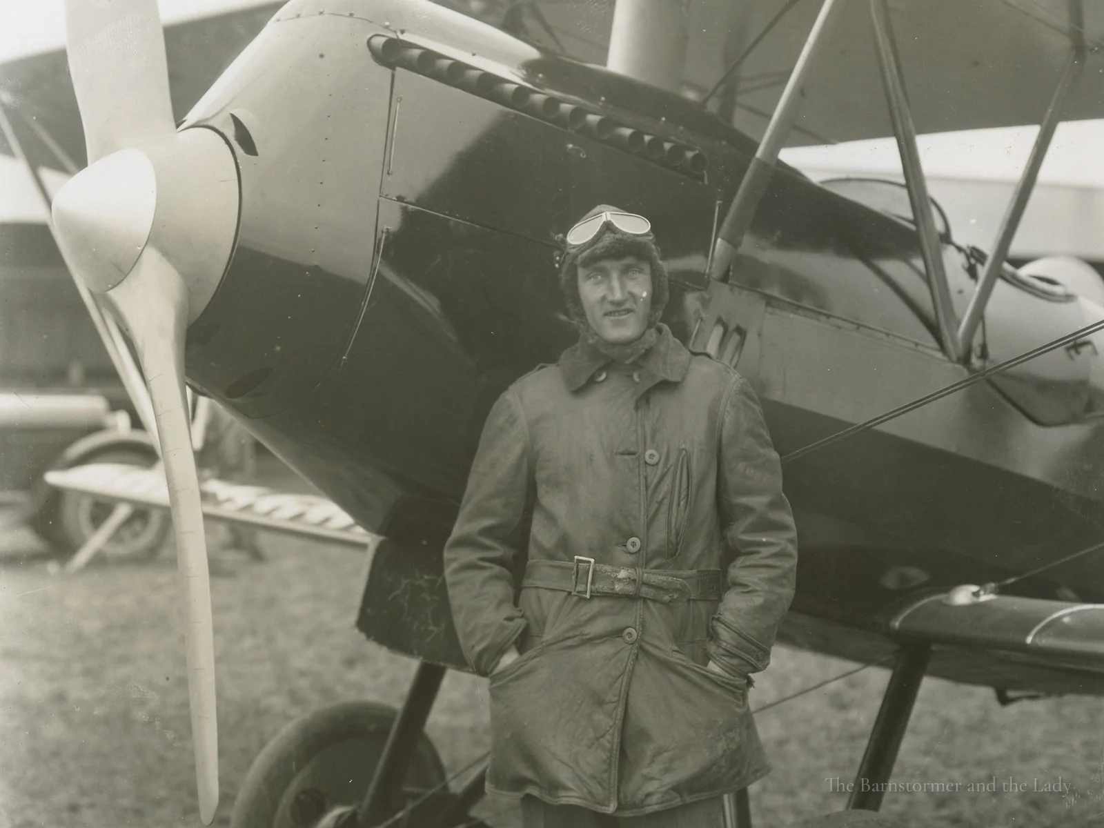 Walter Beech in flying gear standing in front of a biplane