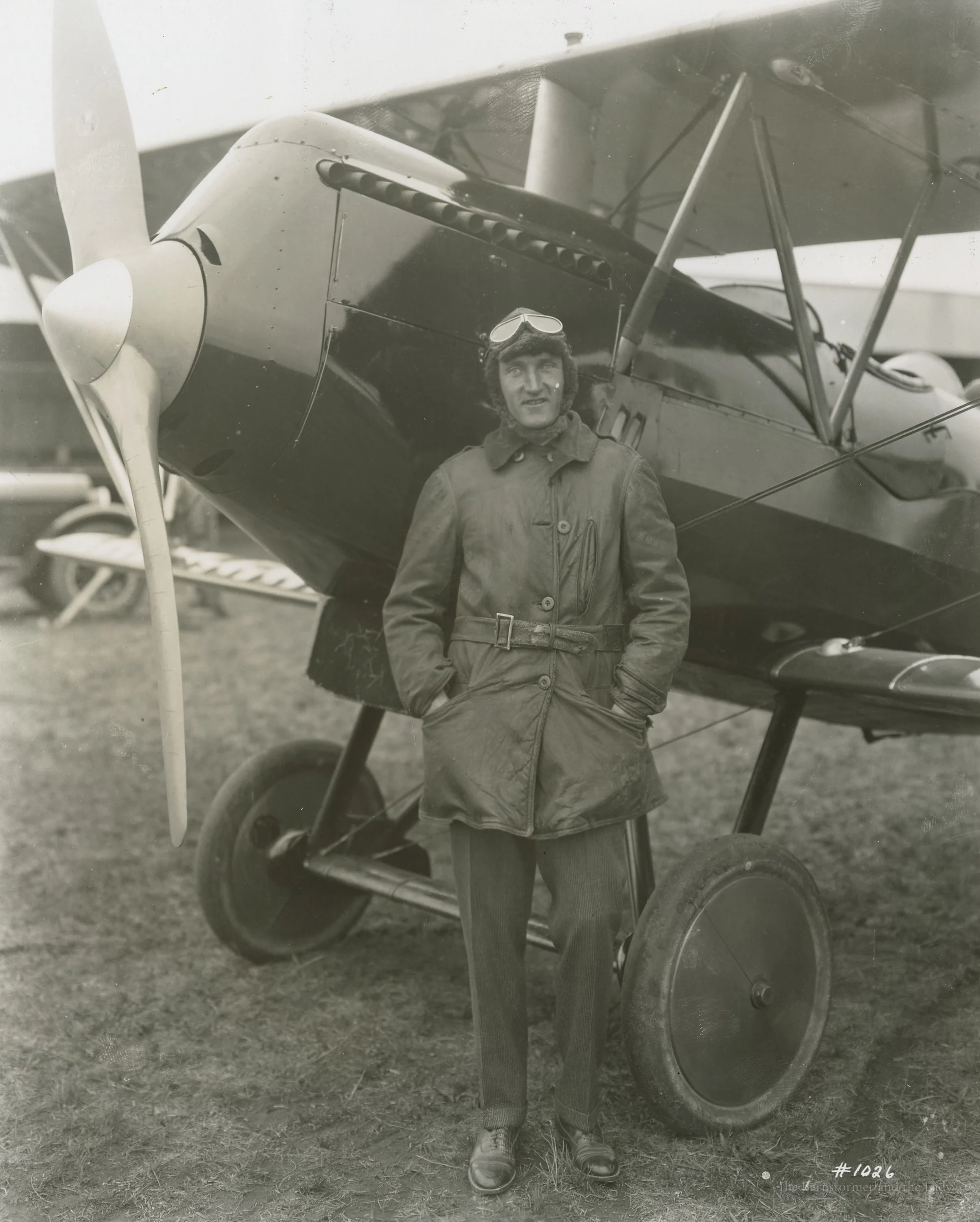 Walter Beech in flying gear standing in front of a biplane