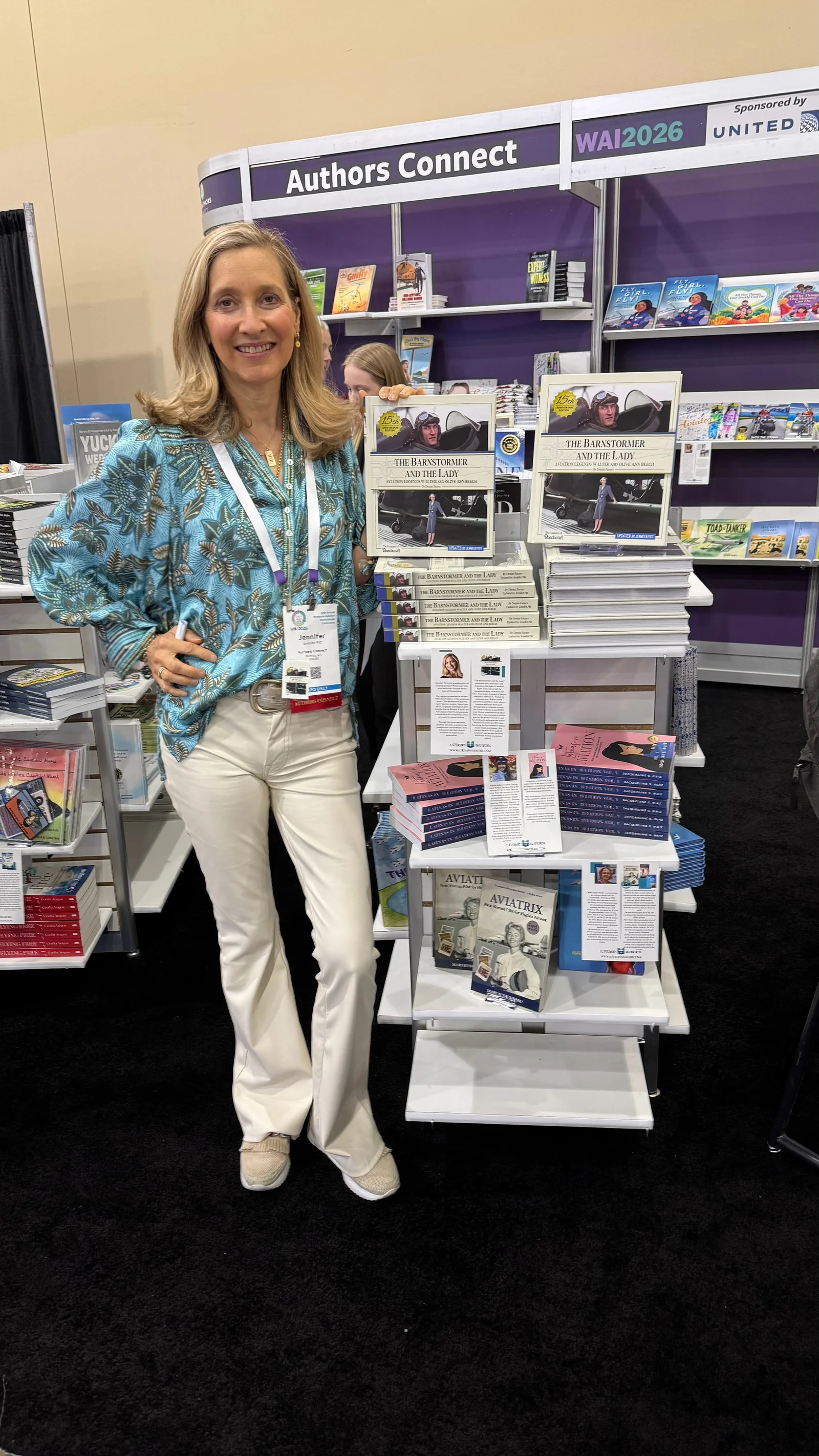 Jennifer Pitt beside a display of the book at an Authors Connect stand