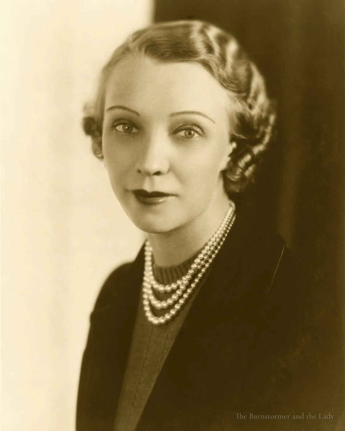 Studio portrait of Olive Ann Beech wearing three strands of pearls