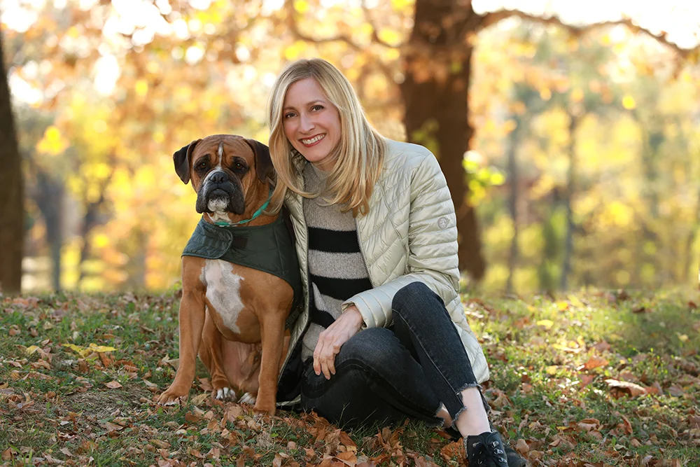 Jennifer Pitt seated outdoors with a dog
